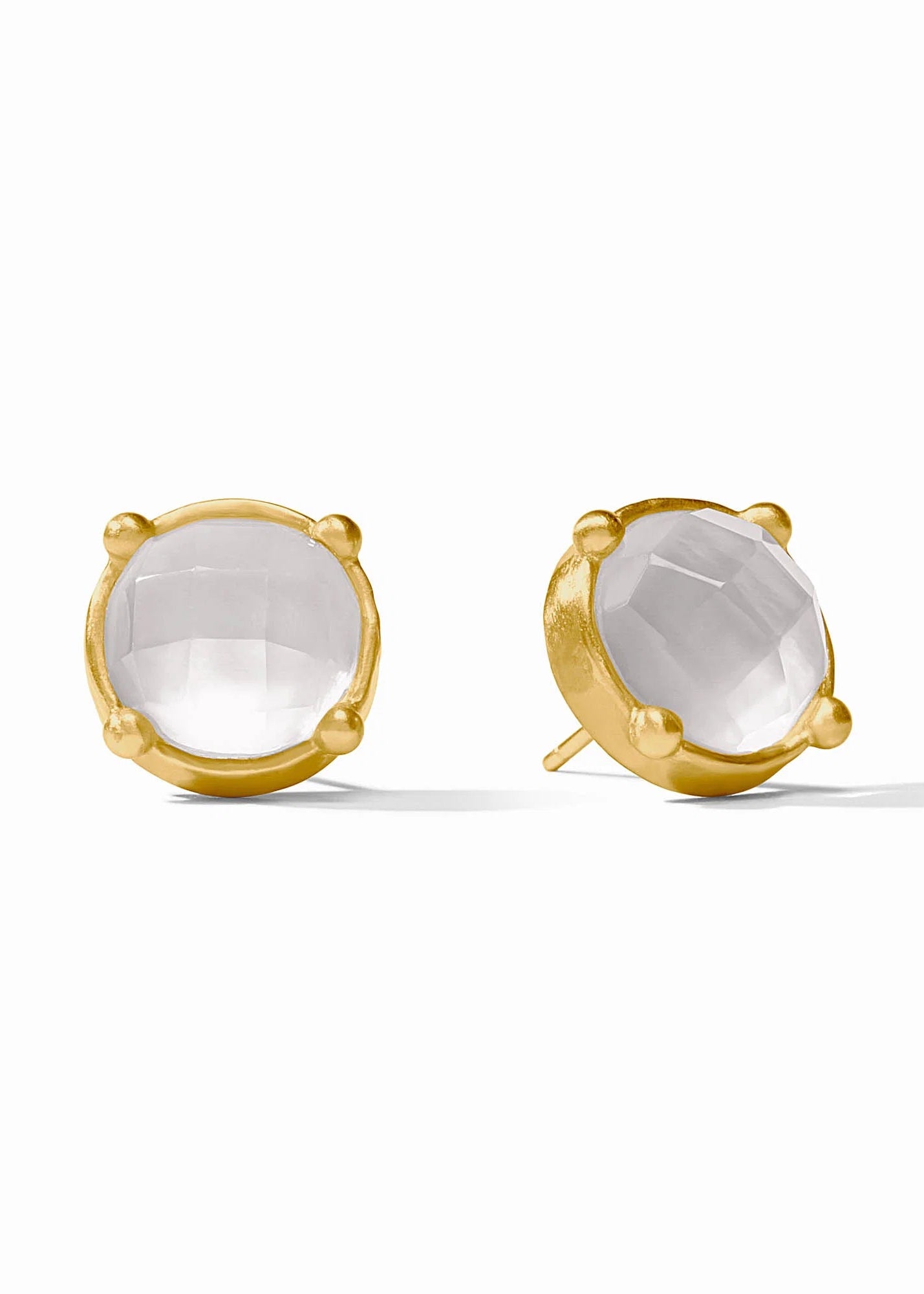 Gold earrings with clear gemstones on a white background