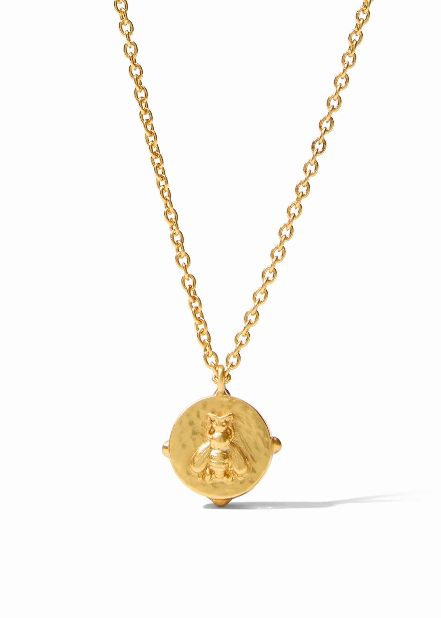 Gold necklace with a round pendant on a white background