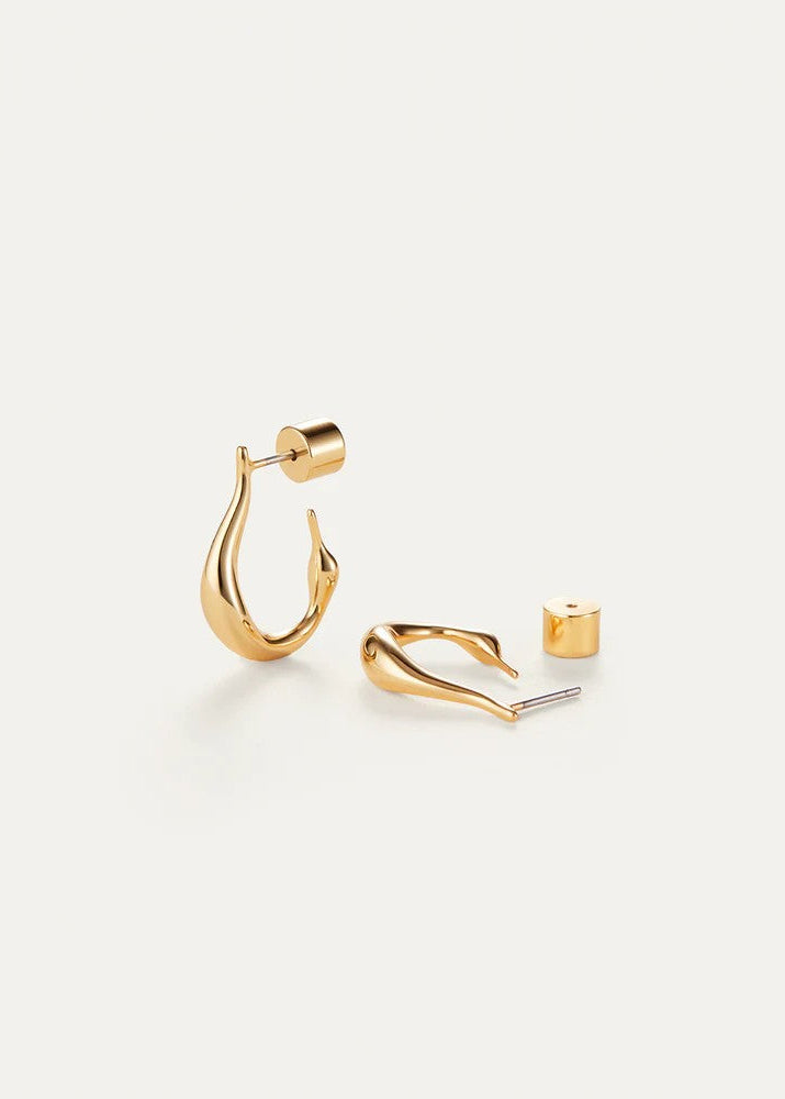 Gold-toned geometric hoop earrings shown on a clean off-white background, with one earring displayed on its post and the other lying on its side showing the front curve and post.