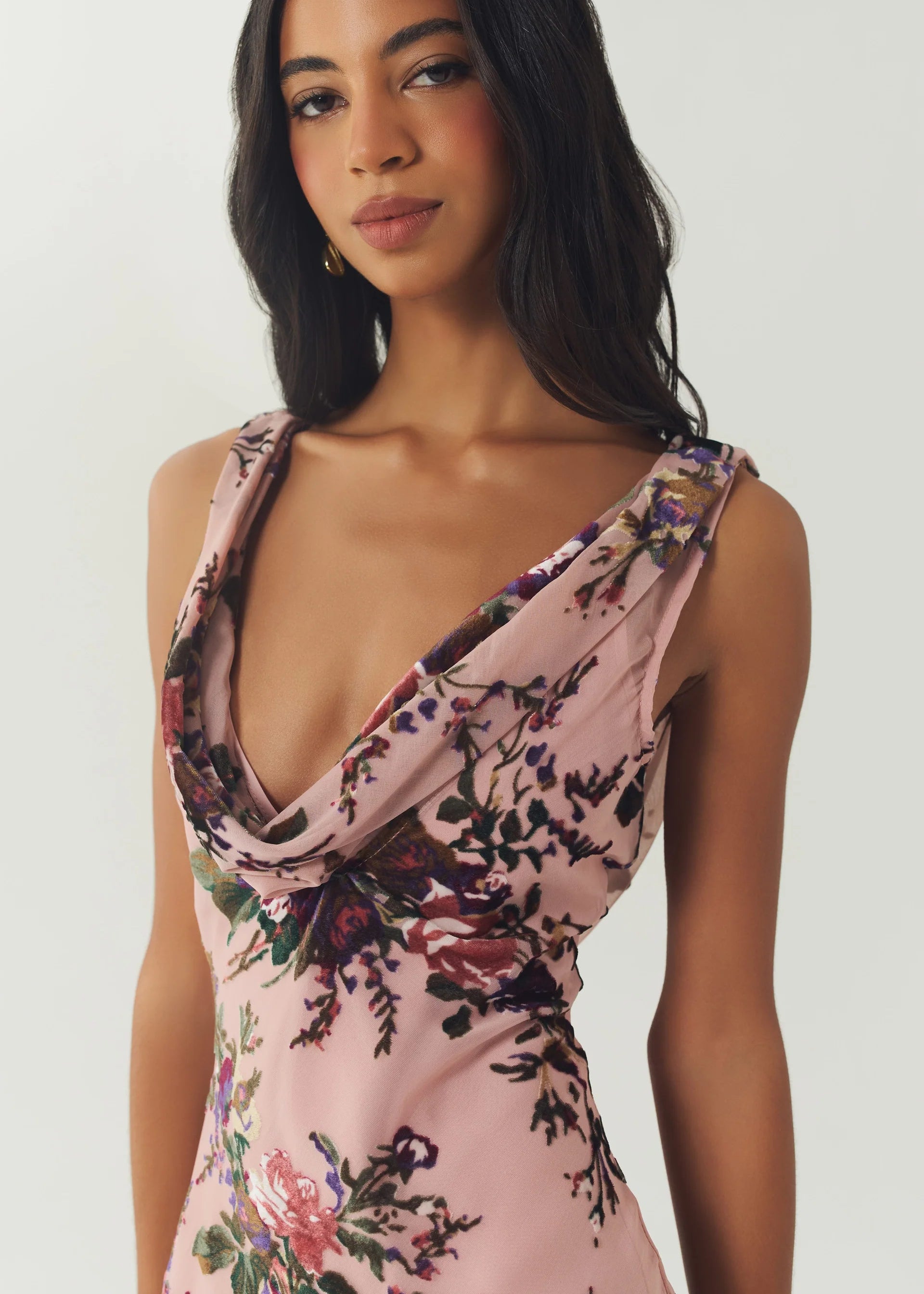 Woman wearing a floral dress with a plain background