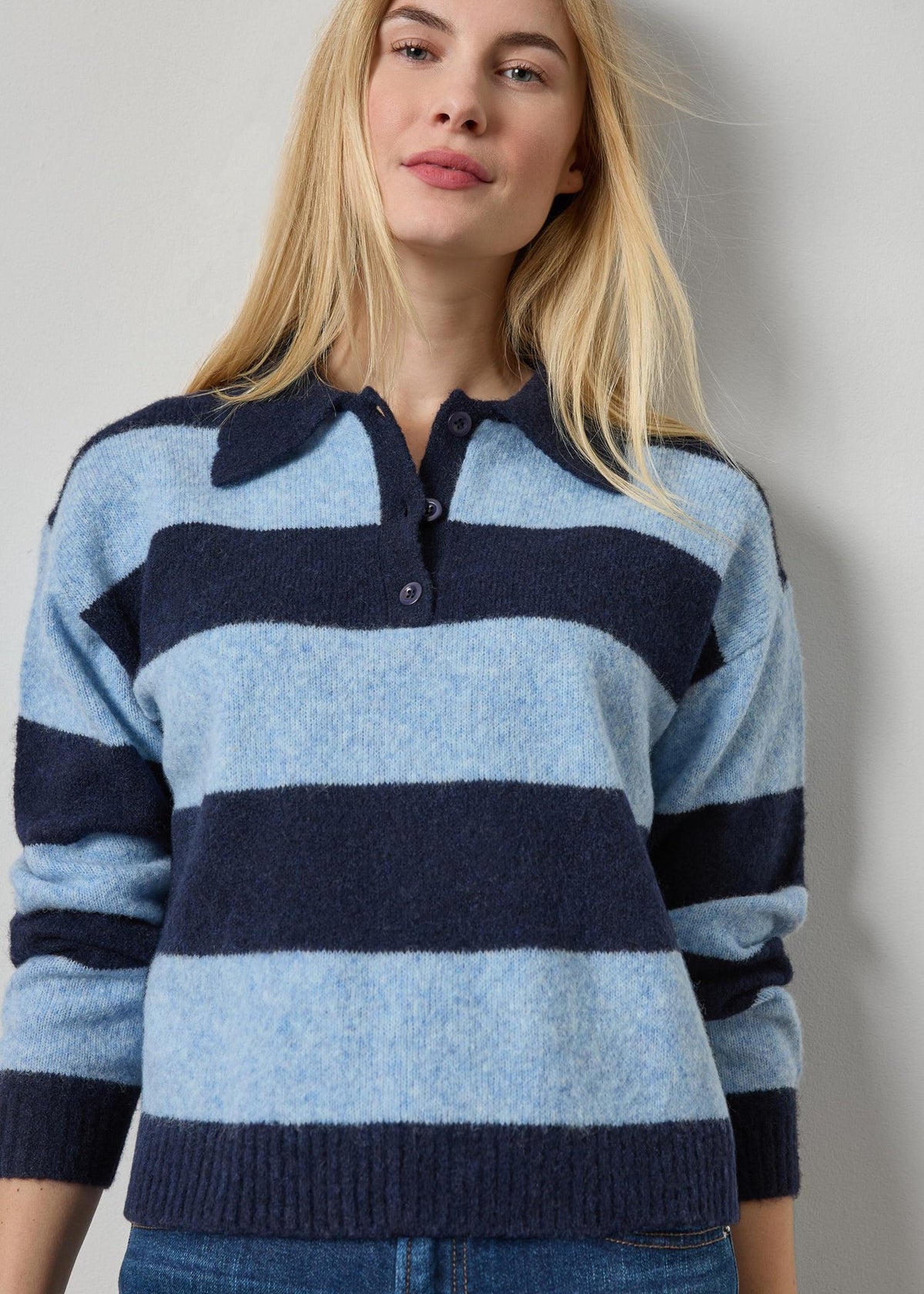 Woman wearing a blue and navy striped sweater against a plain background