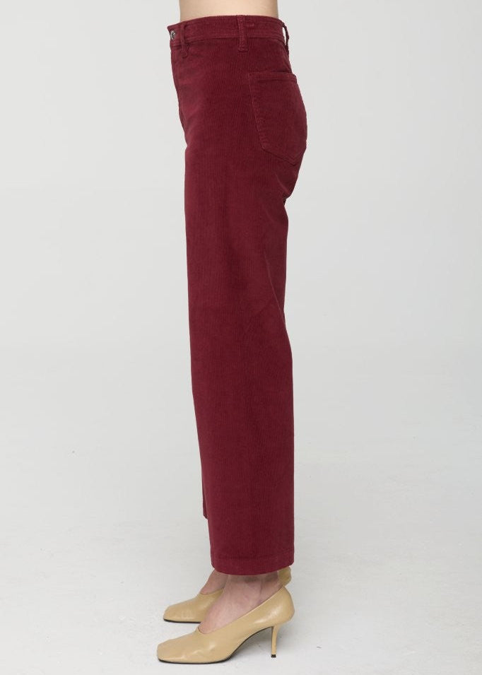 Maroon pants worn by a person on a white background