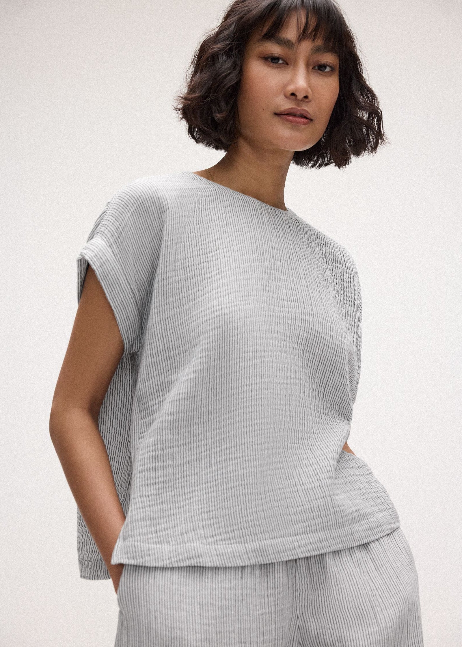 Woman wearing a light gray checkered outfit on a white background