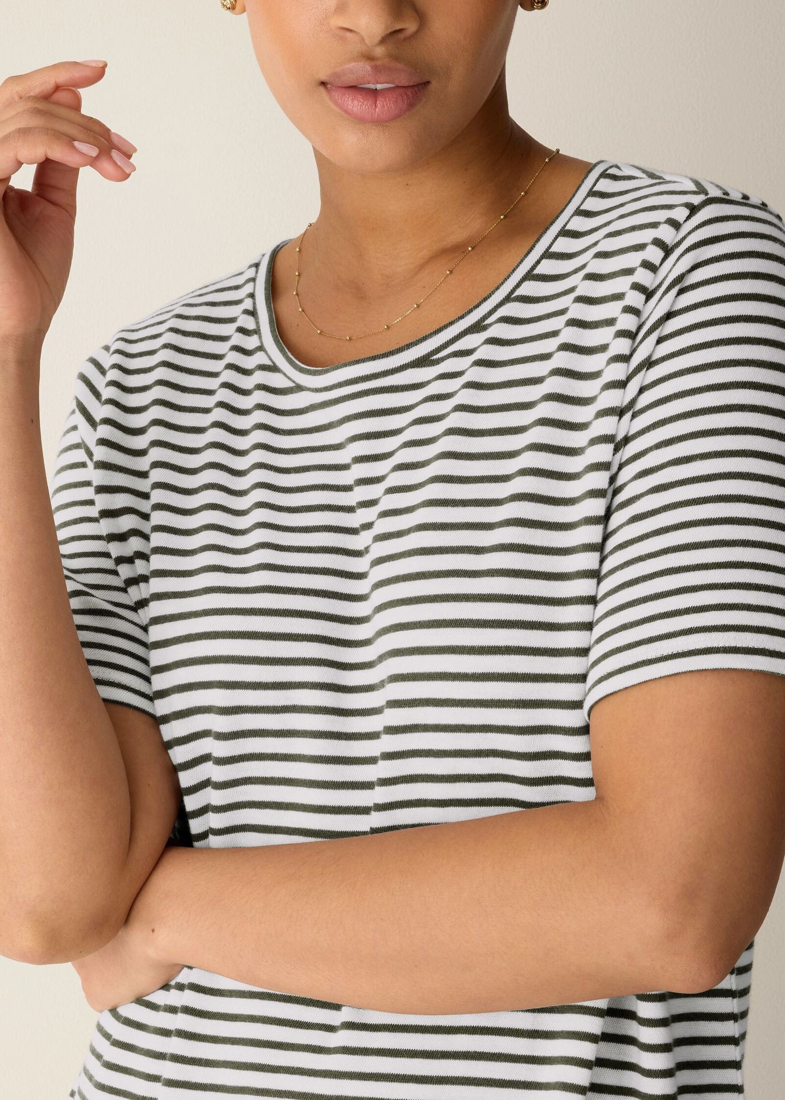 Person wearing a black and white striped shirt against a neutral background