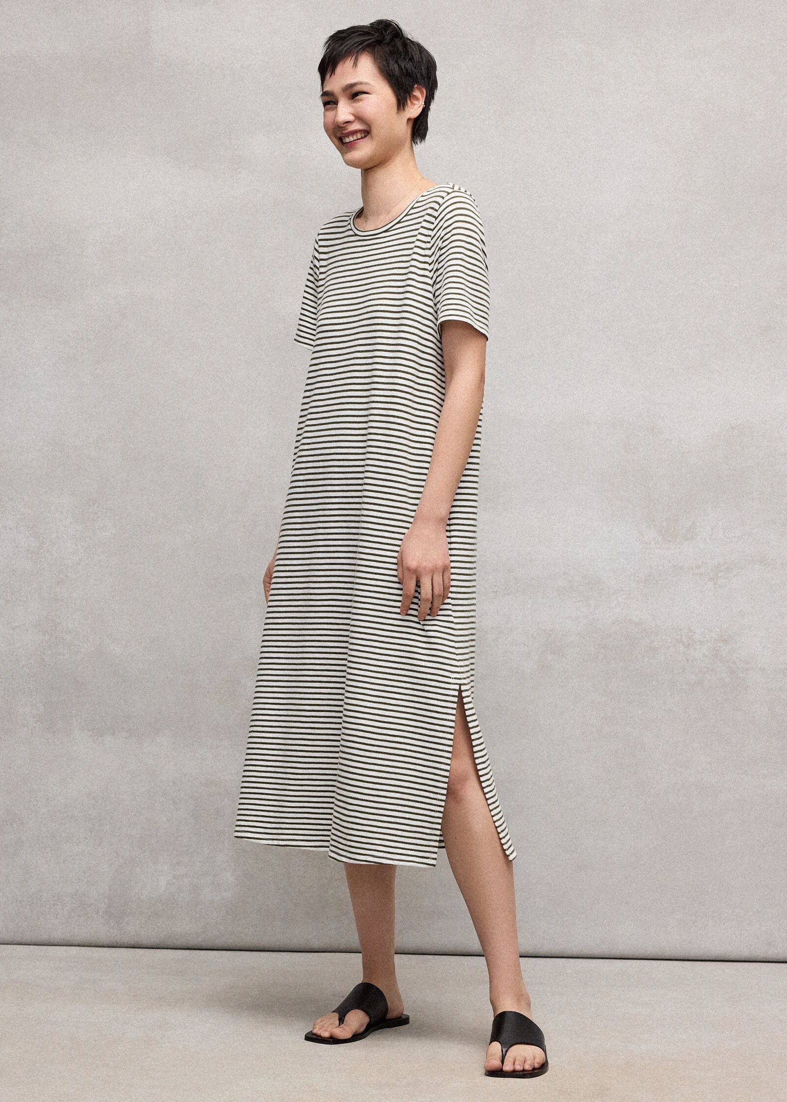 Woman wearing a striped dress against a plain background