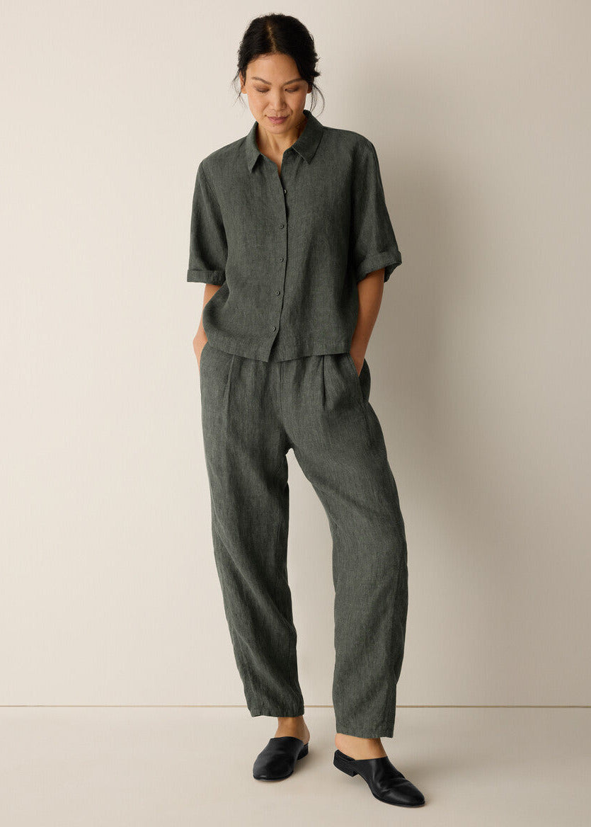 Woman wearing a green outfit against a plain background