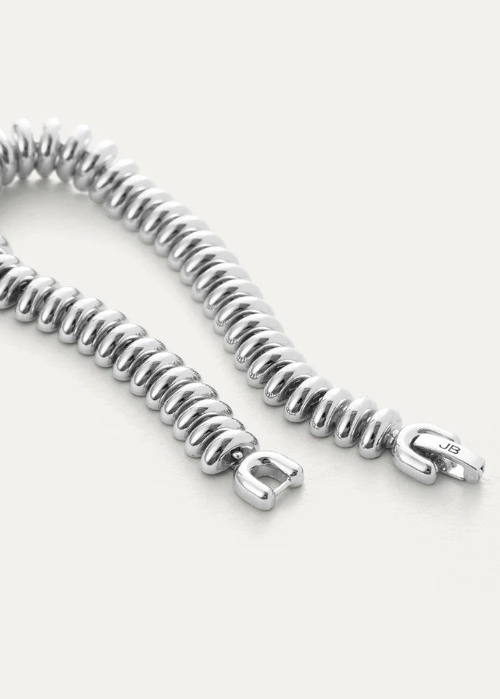 Silver bracelet with a coiled design on a white background