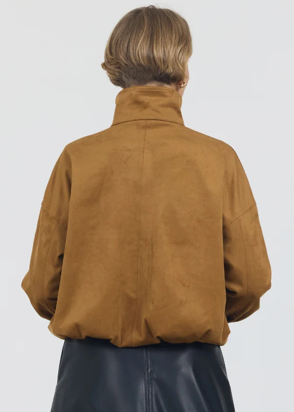 Person wearing a brown suede jacket on a white background