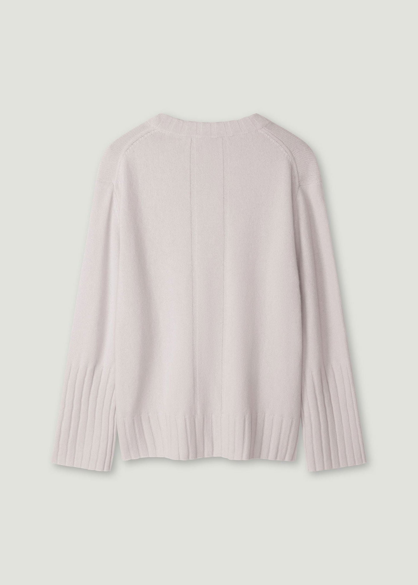 A light pink ribbed knit sweater shown from the back, laid flat against a solid light gray background.