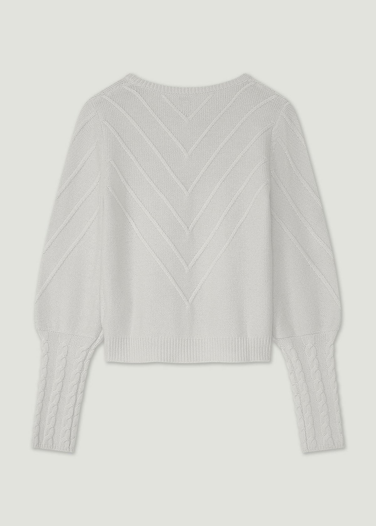 A white cropped knit sweater with long balloon sleeves and a textured chevron pattern on the front, shown against a light gray background.