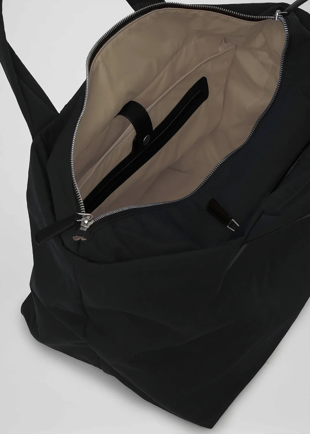 Black backpack with beige interior on a white background