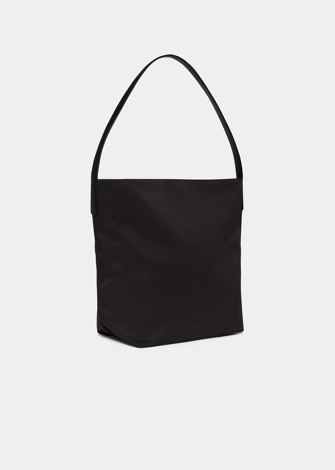 A minimalist black fabric shoulder bag with a single thin strap, shown against a plain light gray background.