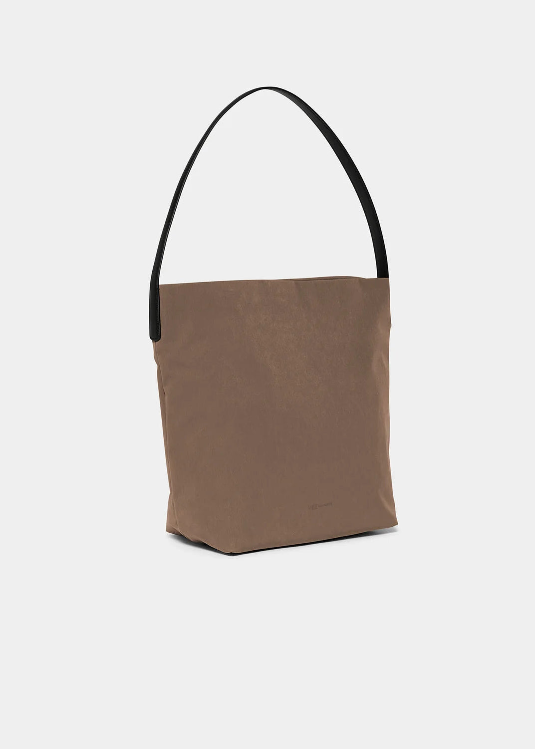A minimalist taupe-brown canvas tote bag with a contrasting black shoulder strap, shown against a clean, light gray background.