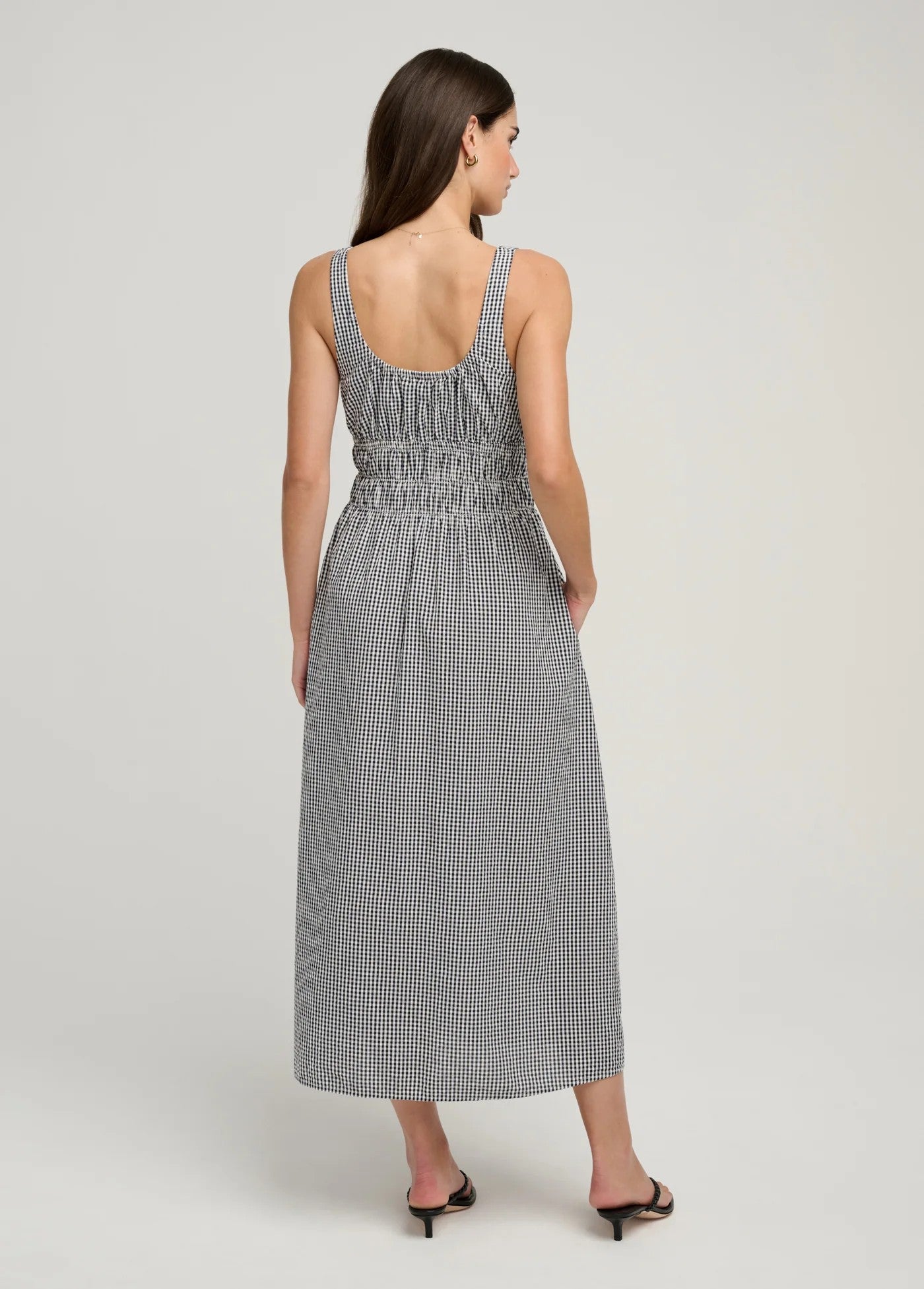 Woman wearing a gray checkered dress on a white background