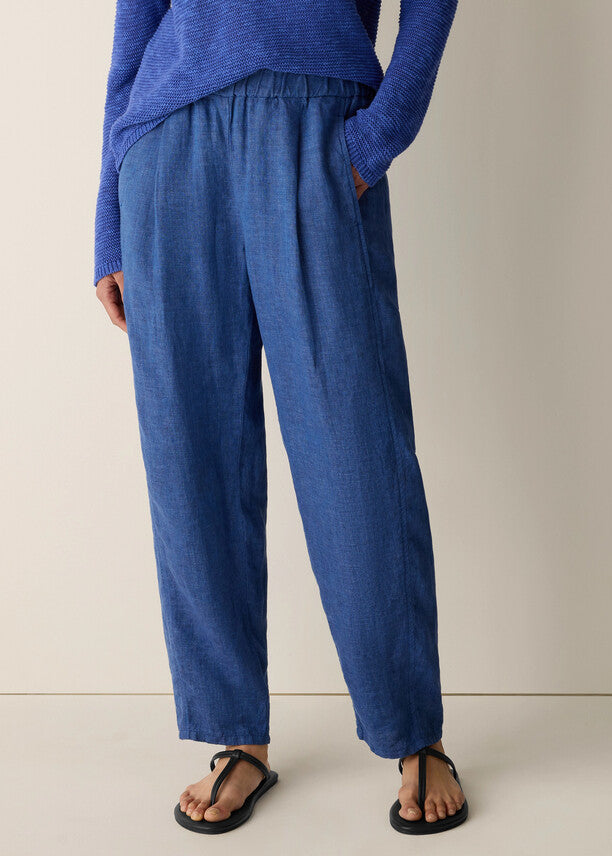 Person wearing blue pants and a blue top on a plain background