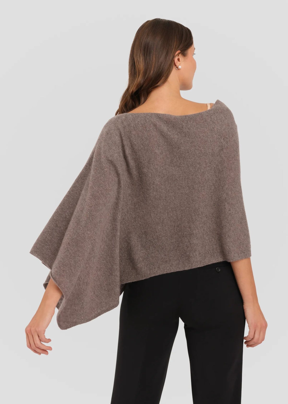 Woman wearing a brown poncho against a white background
