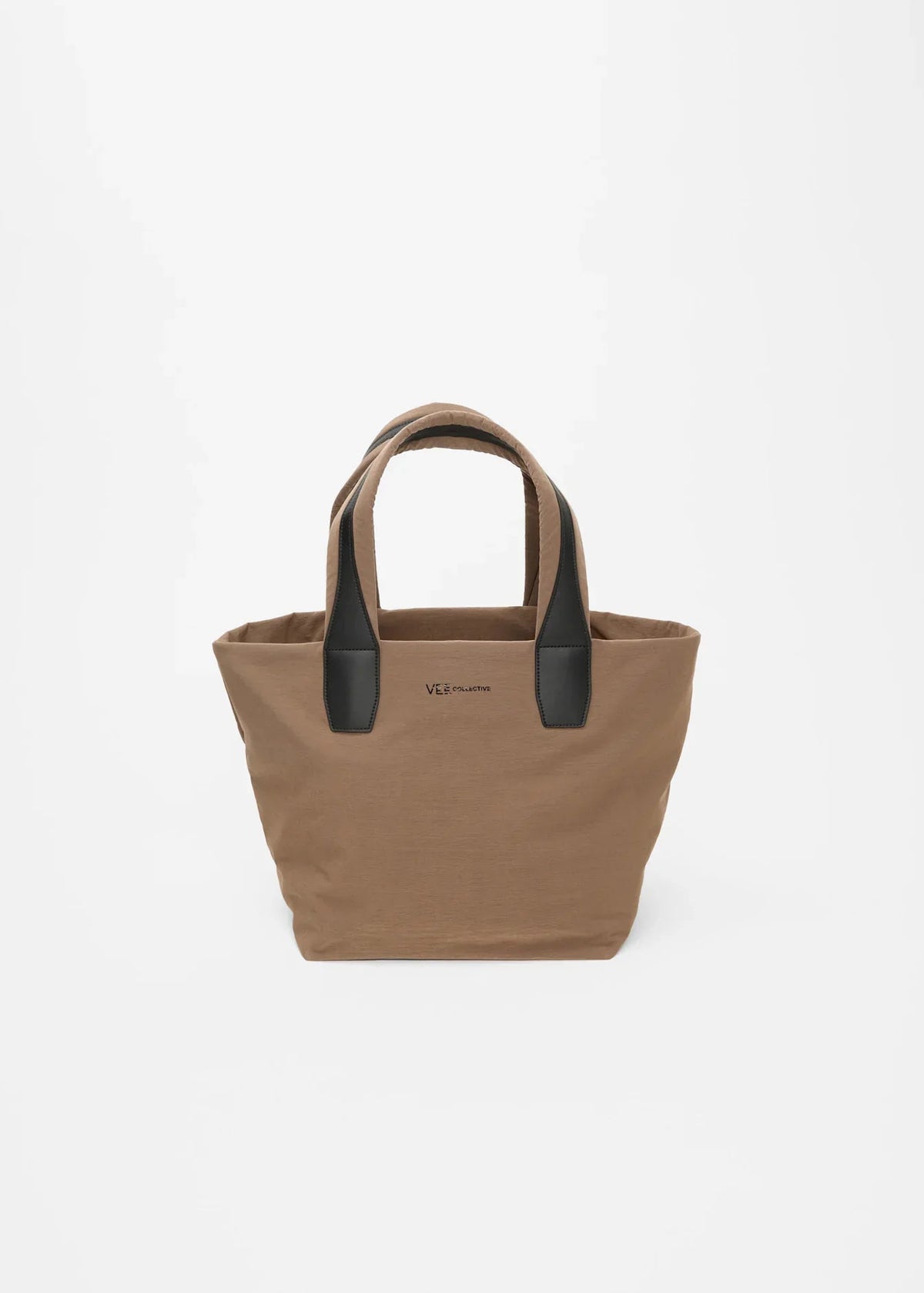 A tan canvas tote bag with black leather handles and a small black logo on the front, photographed against a clean white background.