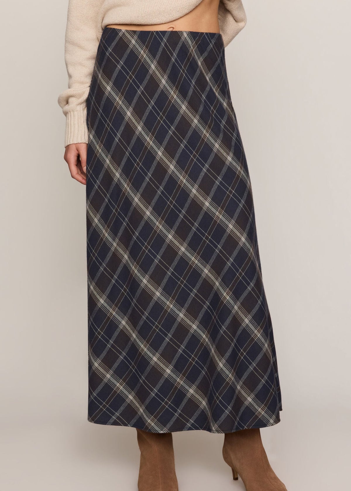 Person wearing a blue plaid skirt on a plain background